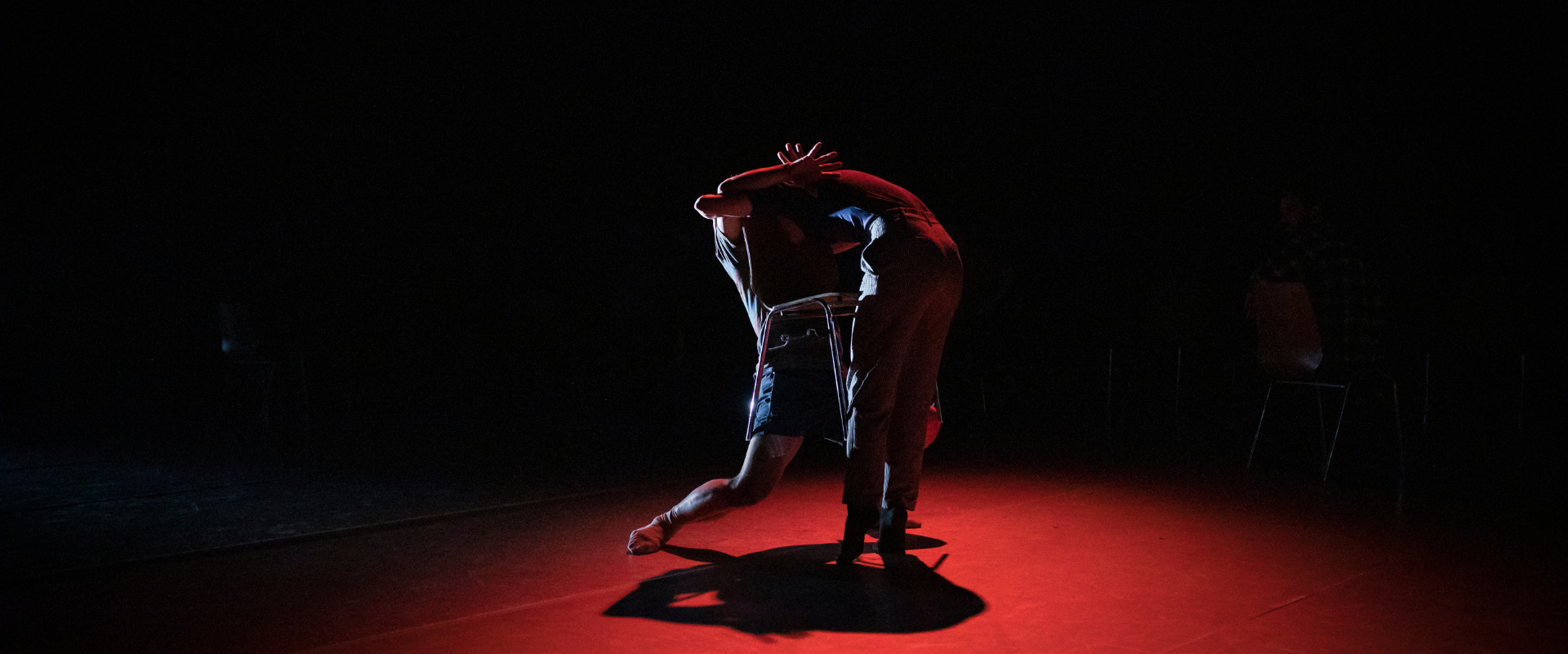 Malcolm Sutherland Scottish Dance Theatre Choreogrpaher placement, figures dance in black and red lighting