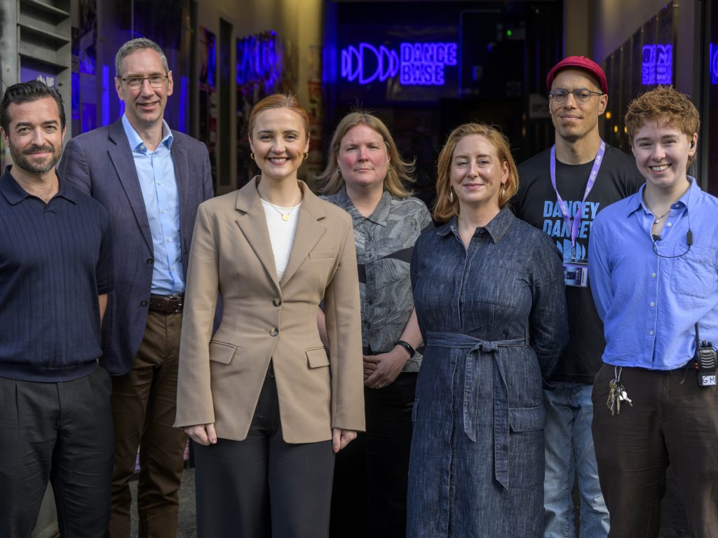 [Image: a group photograph outside the entrance to Dance Base. From left to right: Marc Cairns (Associate Director Scottish Futures Trust), Peter Reekie (CEO Scottish Futures Trust), Màiri McAllan MSP (Cabinet Secretary for Education, Culture and Gaelic), Karen Ridgewell (Climate Emergency and Sustainability Lead, Creative Scotland), Jeanie Scott (CEO, Dance Base), Tony Mills (Artistic Director, Dance Base), Han Joyce (General Manager, Dance Base).]